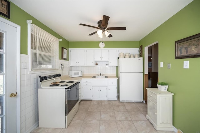 kitchen featuring light countertops, white appliances, white cabinets, and a sink