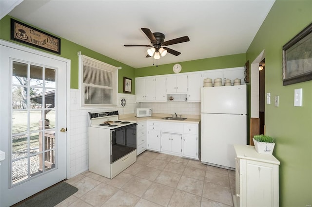 kitchen featuring light countertops, white appliances, white cabinetry, and a sink