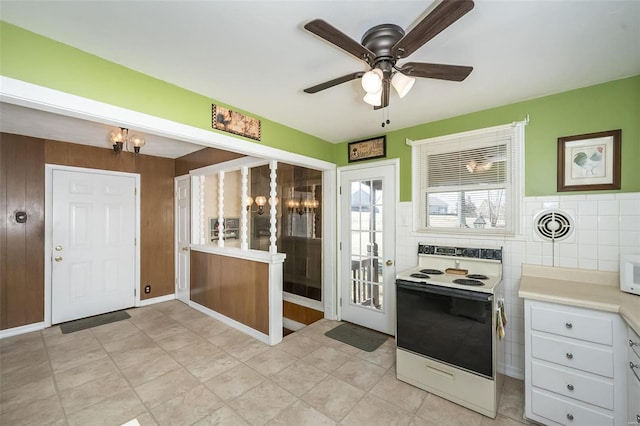 kitchen with ceiling fan with notable chandelier, white appliances, visible vents, tile walls, and light countertops