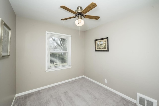 carpeted spare room with ceiling fan, visible vents, and baseboards