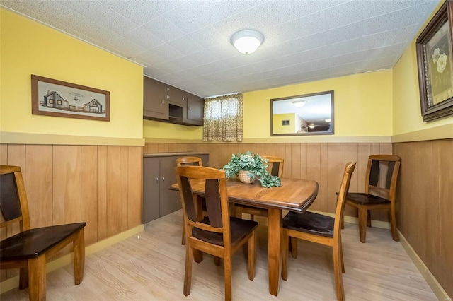 dining room with wainscoting and light wood-style flooring