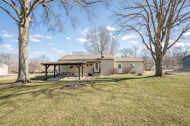 rear view of property featuring entry steps, a yard, a patio area, and fence