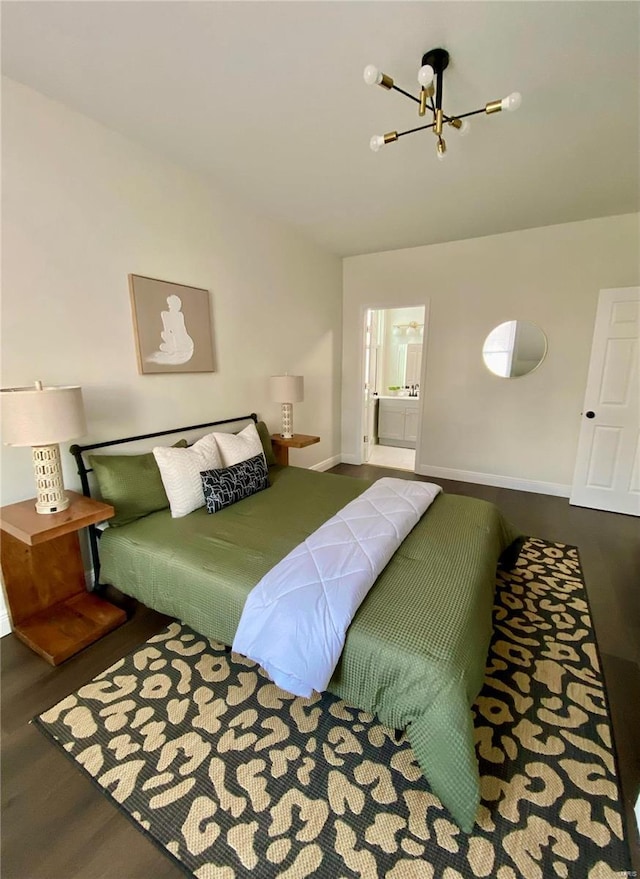 bedroom with a chandelier, ensuite bath, baseboards, and wood finished floors