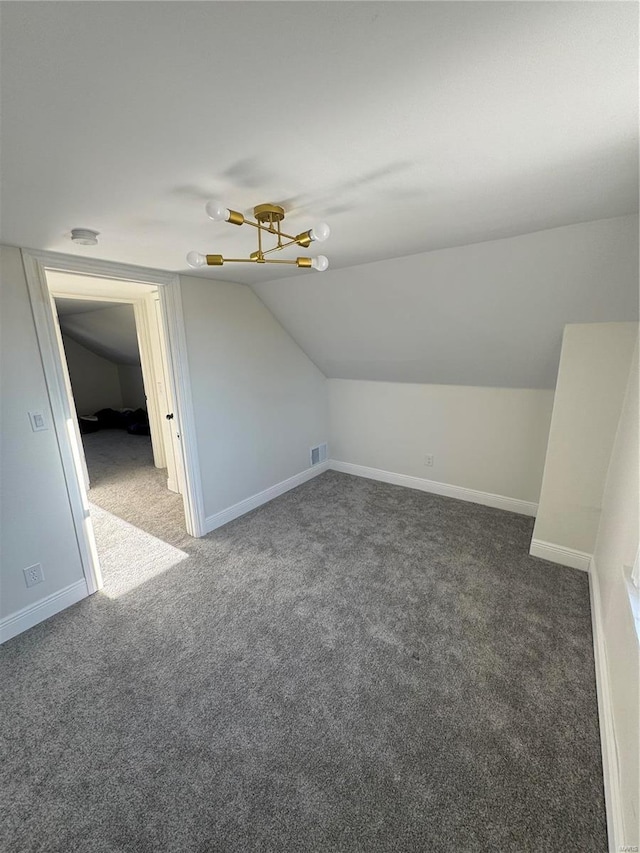 additional living space featuring lofted ceiling, visible vents, baseboards, and carpet flooring