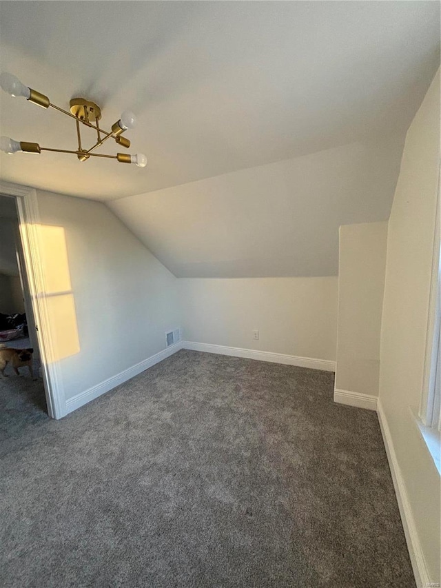 additional living space featuring carpet, visible vents, vaulted ceiling, and baseboards