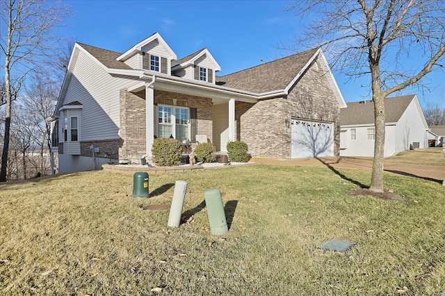 view of front of property with an attached garage, a front lawn, and brick siding