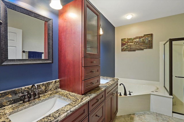 bathroom featuring double vanity, a stall shower, a garden tub, and a sink