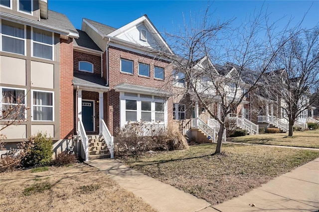 multi unit property with entry steps, a residential view, and brick siding