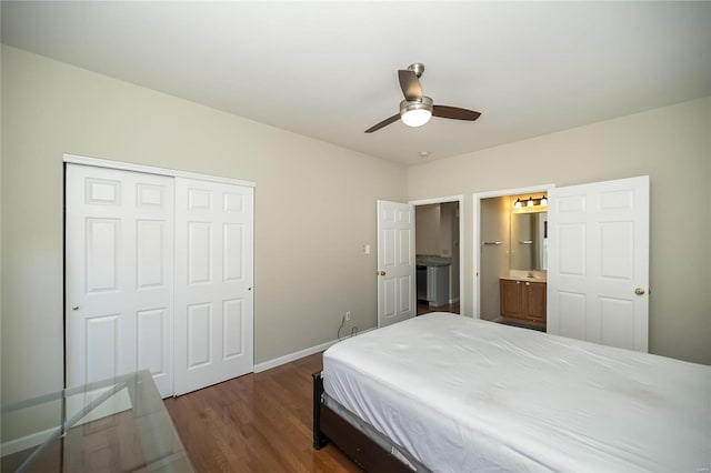 bedroom with baseboards, a ceiling fan, dark wood-style floors, ensuite bath, and a closet