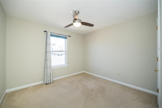 spare room featuring ceiling fan, baseboards, and light colored carpet