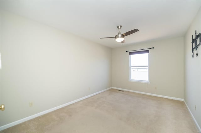 unfurnished room with light carpet, baseboards, and a ceiling fan