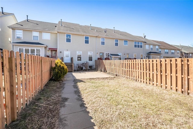 view of yard featuring a patio area, a fenced backyard, and a residential view