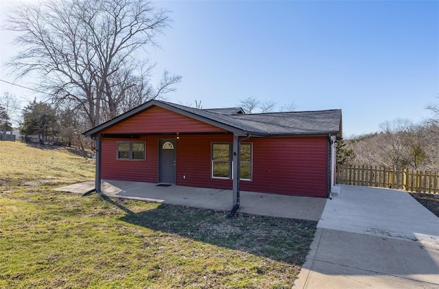 view of front of home with fence, a front lawn, and a patio