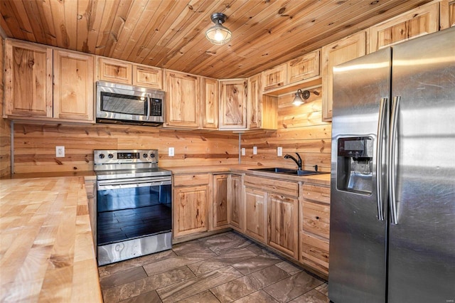 kitchen with wooden ceiling, wood counters, stainless steel appliances, light brown cabinetry, and a sink