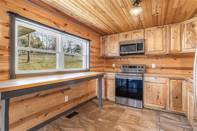 kitchen with wooden ceiling, wooden walls, wooden counters, appliances with stainless steel finishes, and light brown cabinetry