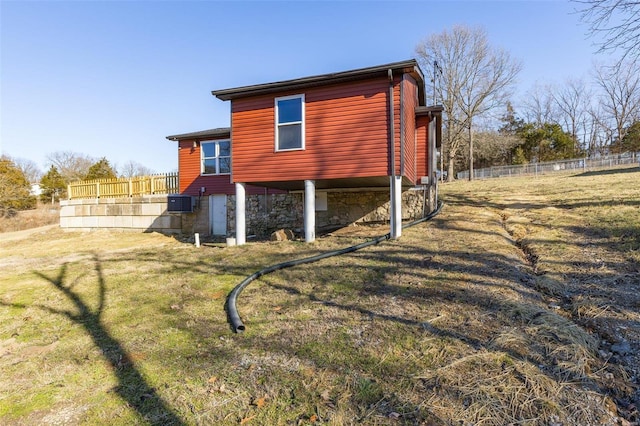 back of house with central AC, a lawn, and fence