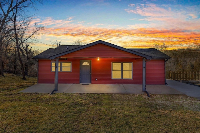 chalet / cabin with a patio, a front lawn, and fence