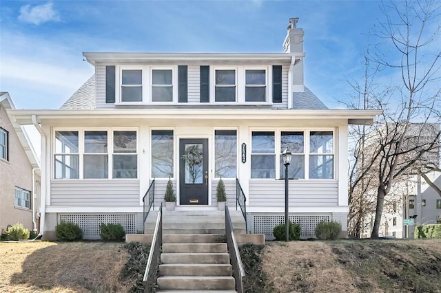 bungalow-style house featuring roof with shingles and a chimney