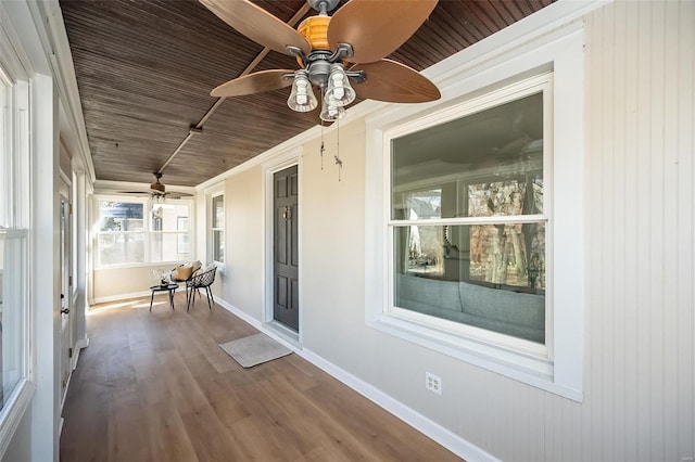 unfurnished sunroom featuring wooden ceiling and ceiling fan