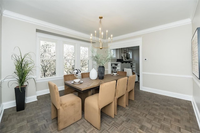 dining room with a notable chandelier, crown molding, and baseboards