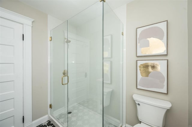 full bathroom with toilet, a stall shower, and baseboards