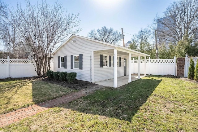 view of side of property featuring a yard, fence private yard, and a patio