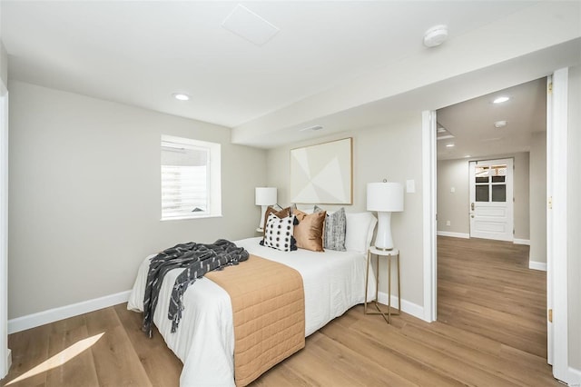 bedroom with baseboards, wood finished floors, and recessed lighting