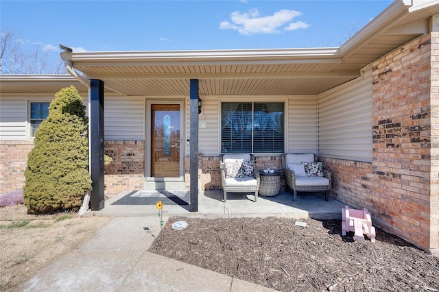 property entrance with brick siding and a porch