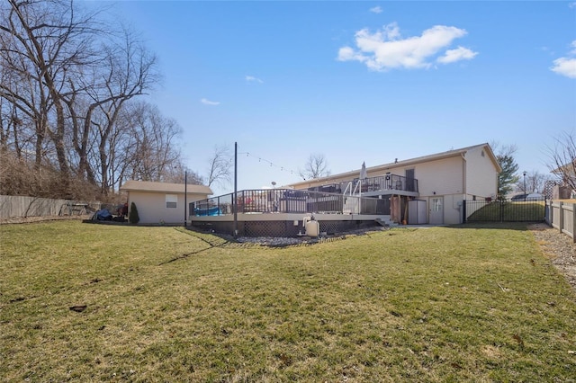 back of house featuring a deck, a lawn, a fenced backyard, and a gate