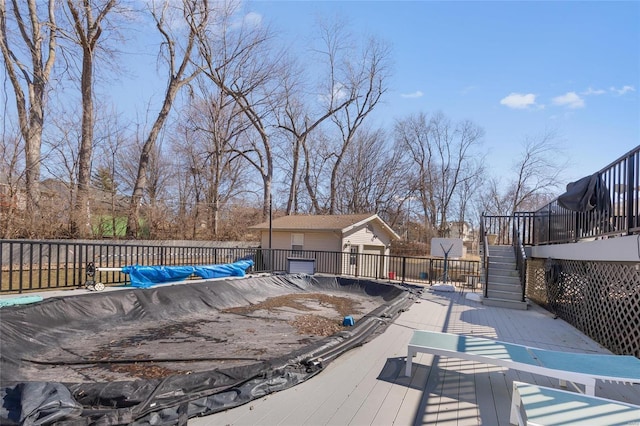 deck with fence, stairway, a fenced in pool, and an outbuilding