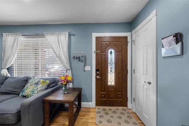 foyer entrance featuring light wood-style flooring and baseboards