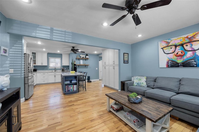 living room with recessed lighting, baseboards, ceiling fan, and light wood finished floors