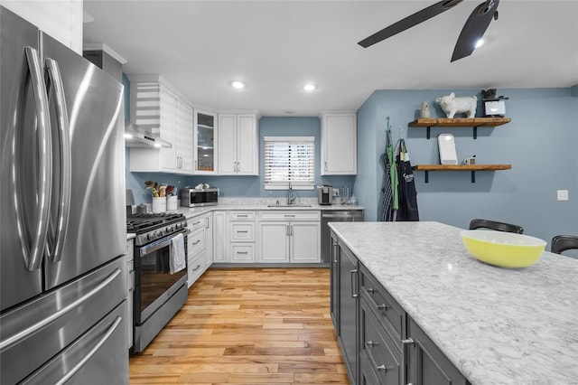 kitchen with stainless steel appliances, light wood-type flooring, light countertops, and white cabinetry