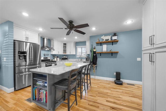 kitchen with wall chimney exhaust hood, a breakfast bar, stainless steel appliances, white cabinetry, and open shelves