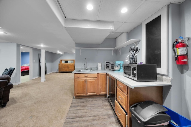 kitchen featuring open shelves, light countertops, stainless steel microwave, open floor plan, and a sink