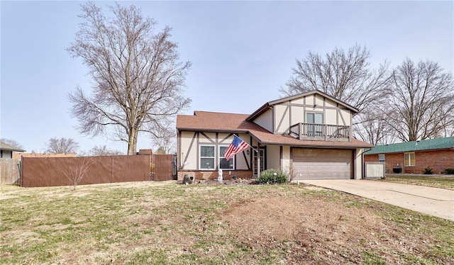 tudor home with concrete driveway, fence, a balcony, and an attached garage