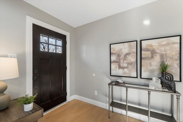 entryway with light wood finished floors and baseboards