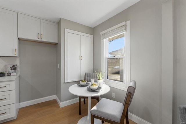 dining room featuring light wood-type flooring and baseboards