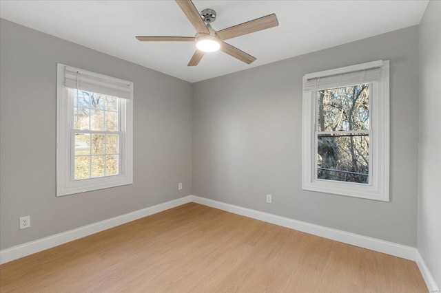 unfurnished room featuring a ceiling fan, light wood-type flooring, and baseboards