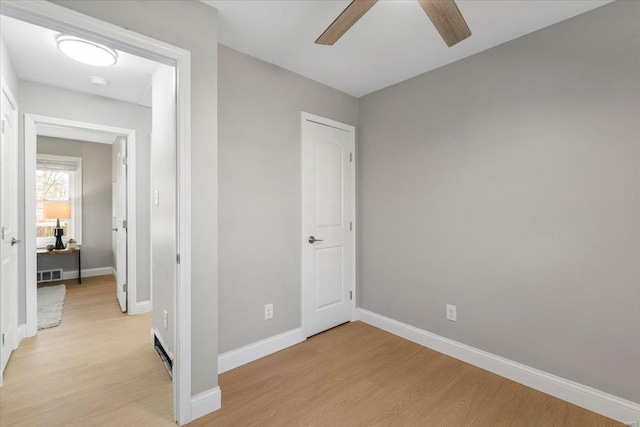 unfurnished bedroom featuring ceiling fan, visible vents, light wood-style flooring, and baseboards