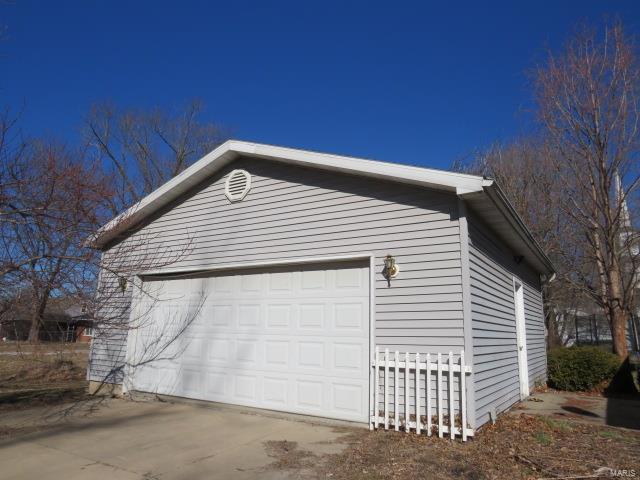 view of home's exterior with driveway and an outbuilding