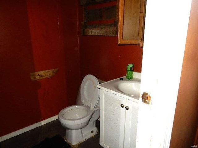 bathroom with vanity, toilet, and baseboards