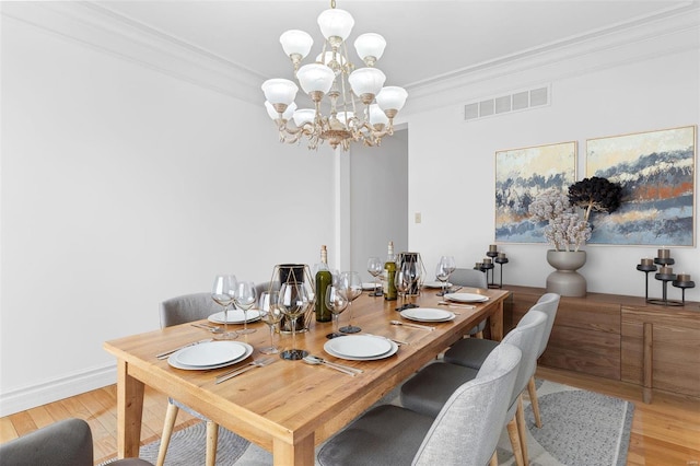 dining room with crown molding, visible vents, a notable chandelier, and light wood-style flooring