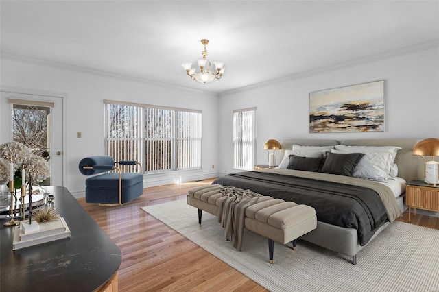 bedroom with an inviting chandelier, baseboards, ornamental molding, and light wood finished floors