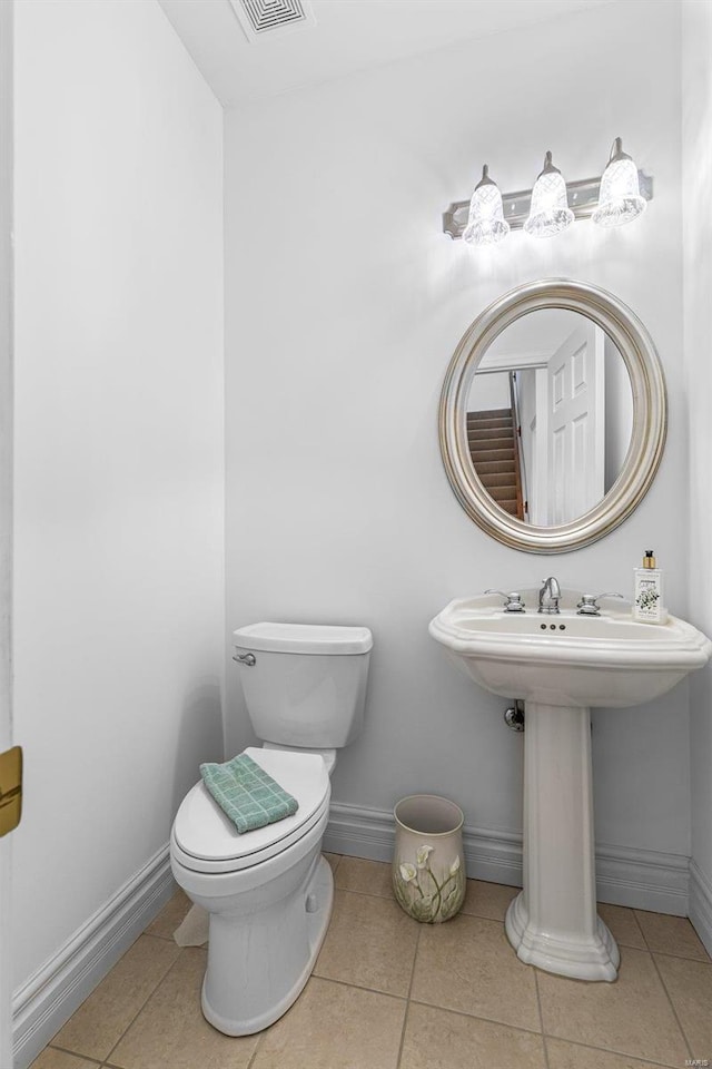 bathroom with baseboards, visible vents, toilet, and tile patterned floors