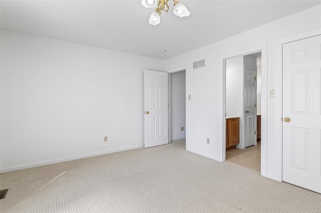 unfurnished bedroom featuring visible vents, ensuite bath, light carpet, and baseboards