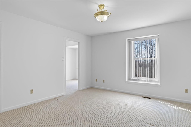 unfurnished room with visible vents, baseboards, and light colored carpet