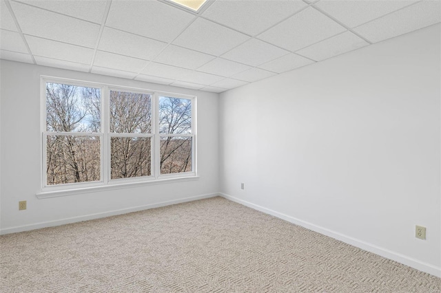 unfurnished room with carpet floors, a healthy amount of sunlight, and a paneled ceiling