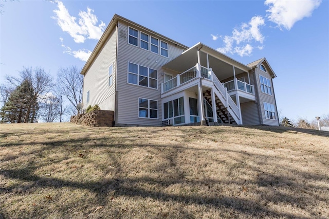 back of property featuring a lawn and stairway