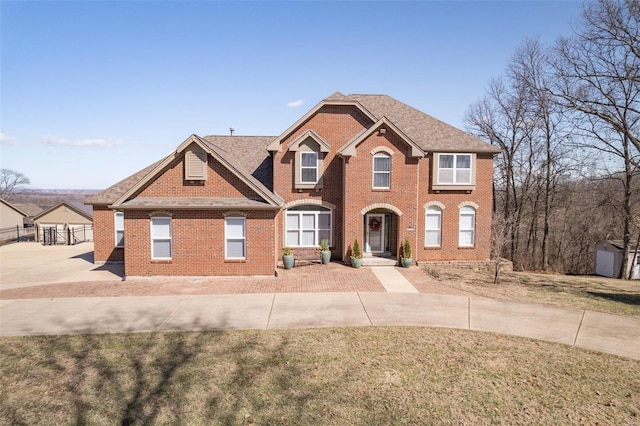 view of front of home featuring a front yard, fence, and brick siding